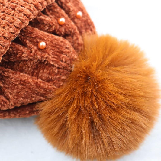 women's winter knitted beanie hat with a pom-pom and pearl embellishments.